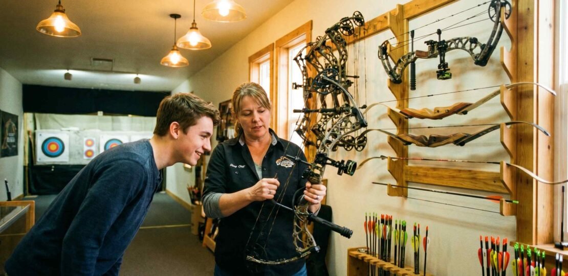 Archery Pro Shop Interior – Expert Staff Fitting a Beginner