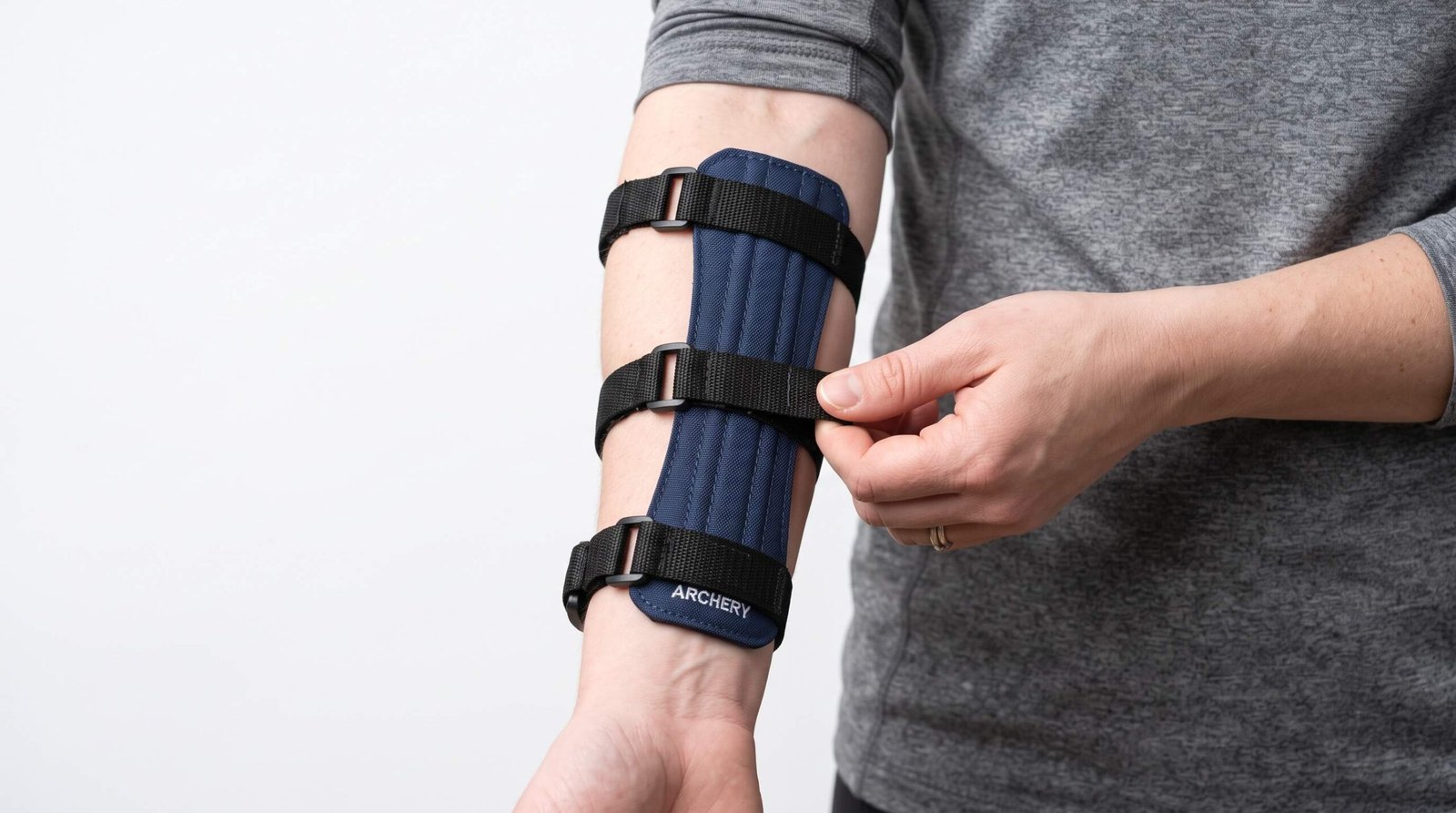 Proper arm guard placement on inner forearm showing correct positioning from wrist to below elbow with snug strap adjustment
